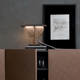 Decorative lamp on a shelf with a framed picture on a gray wall