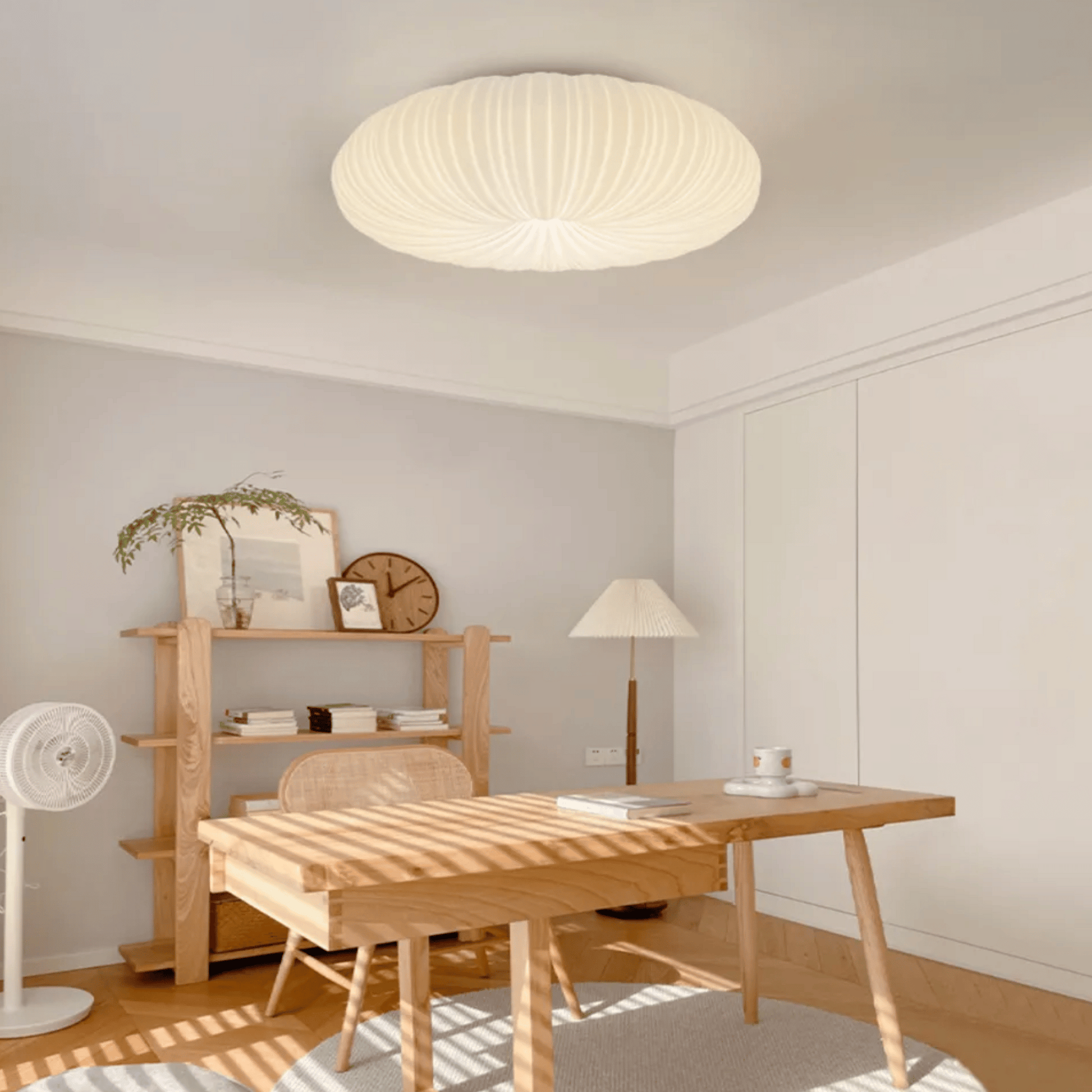 Modern home office with wooden desk, shelves, and ceiling light fixture.
