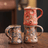 Three ceramic mugs with textured, multicolored glaze on a wooden surface.
