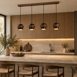 Four modern pendant lights with dark wood and black metal shades hang over a stone-topped kitchen island in a warm, contemporary kitchen setting.