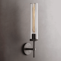 Modern wall-mounted light fixture with clear cylindrical glass shade on a gray background