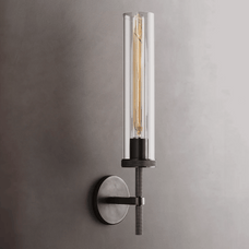 Modern wall-mounted light fixture with clear cylindrical glass shade on a gray background