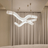 Modern chandelier hanging above a sofa with beige curtains in the background