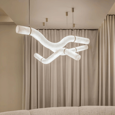 Modern chandelier hanging above a sofa with beige curtains in the background