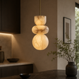 Marble-textured pendant light hanging in a room with a neutral color scheme.