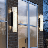 Modern outdoor wall lights on a brick building with glass windows.