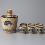 Ceramic decanter set with fish design on a gray background