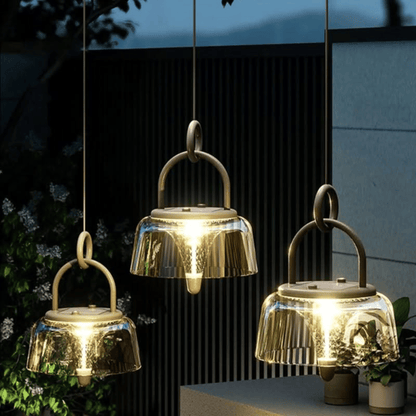 Three hanging solar lights emitting a warm glow outdoors.