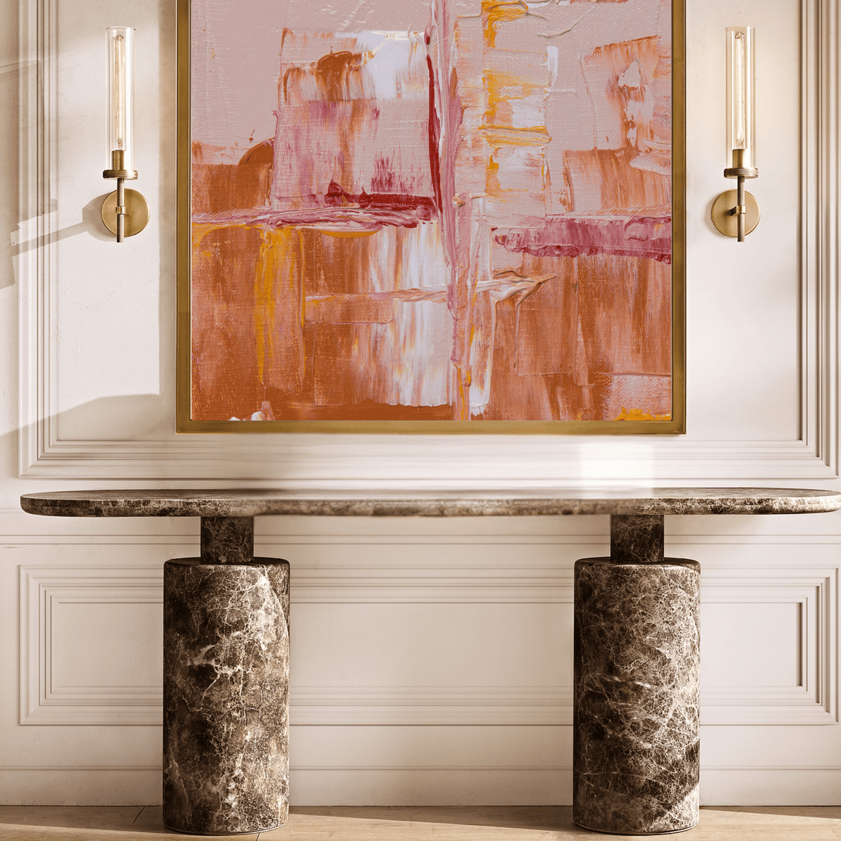 Abstract painting on a wall above a marble console table with sconces on either side.