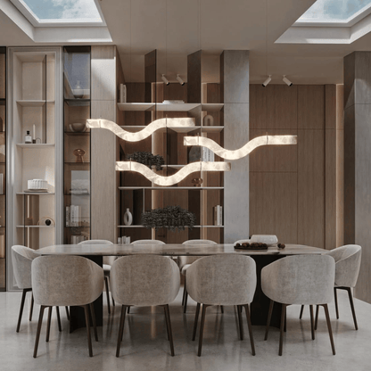 Modern dining room with a long table and chairs, featuring a stylish chandelier.