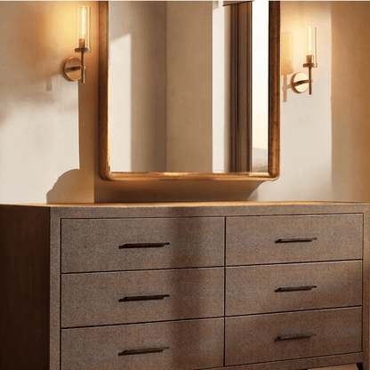 Bathroom vanity with large mirror, lights, and textured drawers.