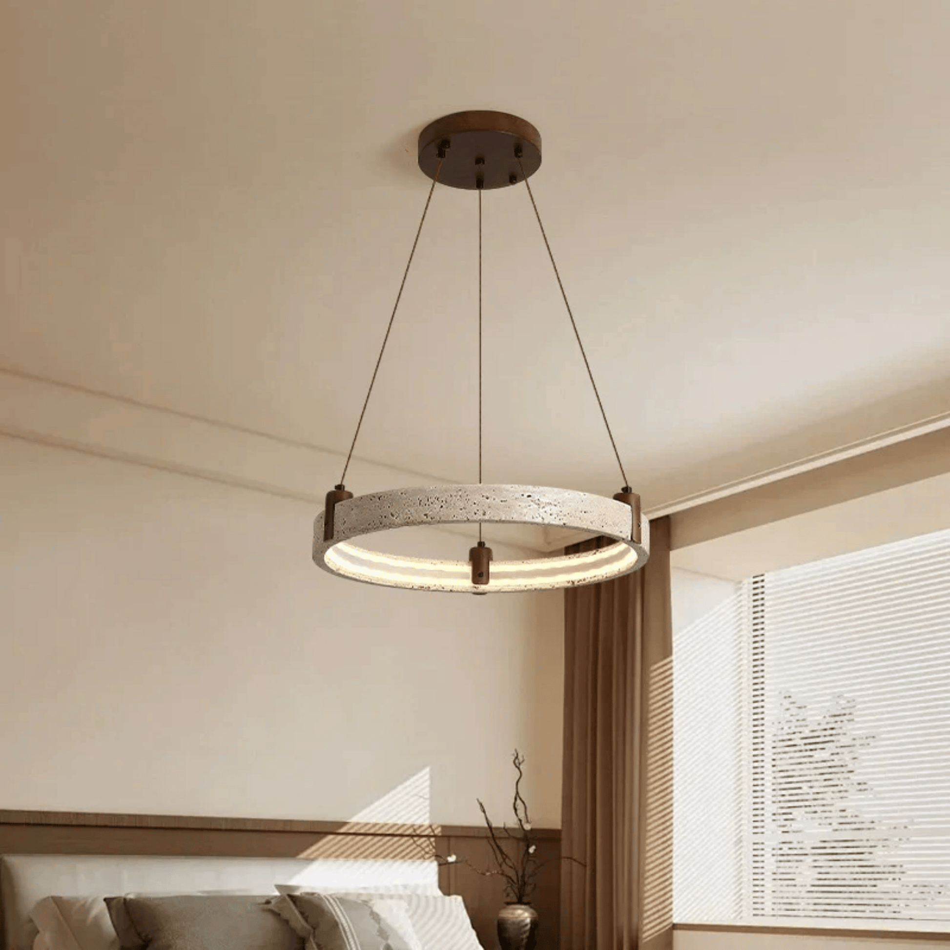 Modern pendant light hanging in a room with neutral walls and a window.