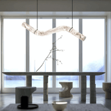 Modern interior with a long dining table and abstract light fixture.