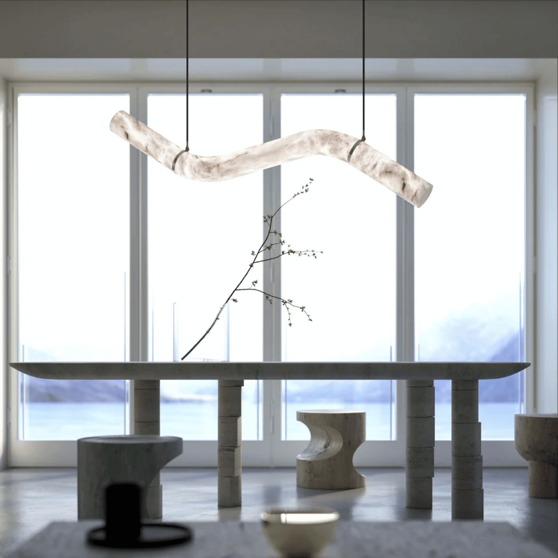 Modern interior with a long dining table and abstract light fixture.