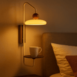 Wall-mounted lamp with a cup on a shelf in a cozy room.