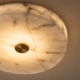 Marble-patterned light fixture with a gold center on a beige background