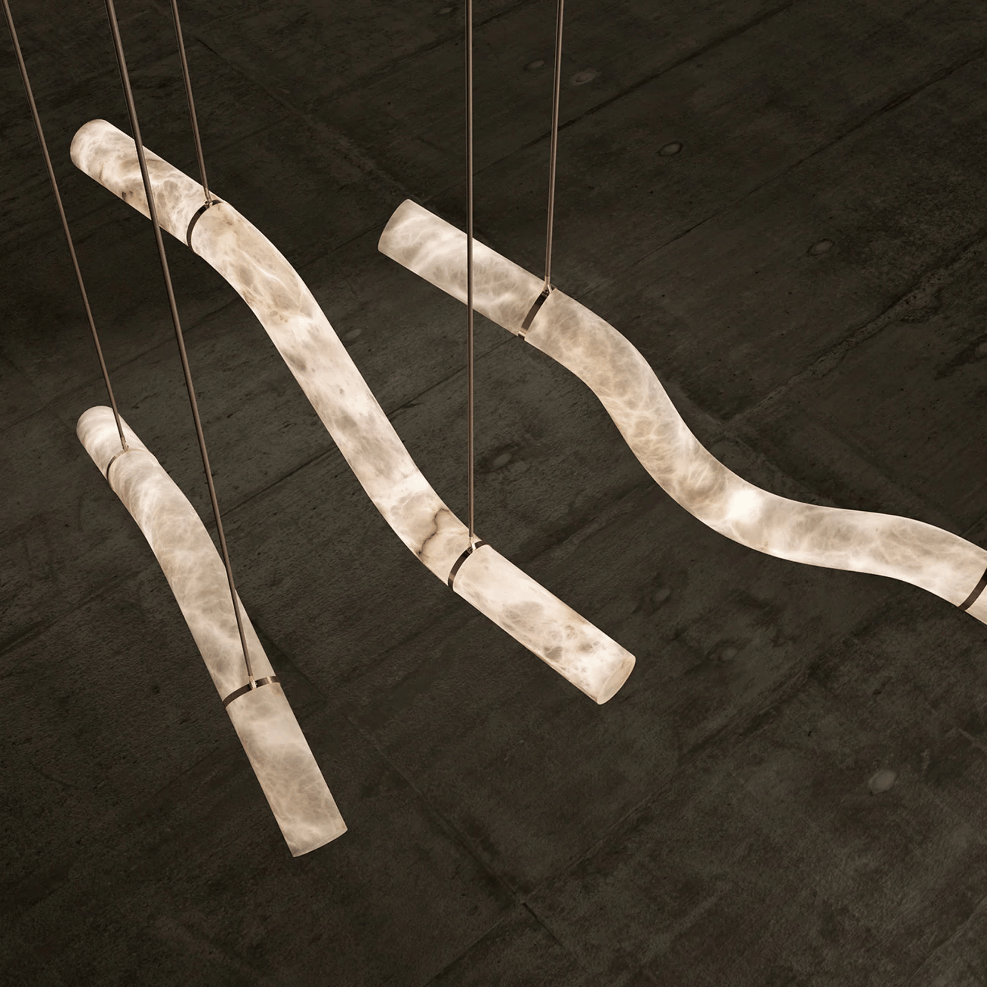 Decorative light fixture with curved metal rods on a dark wooden background