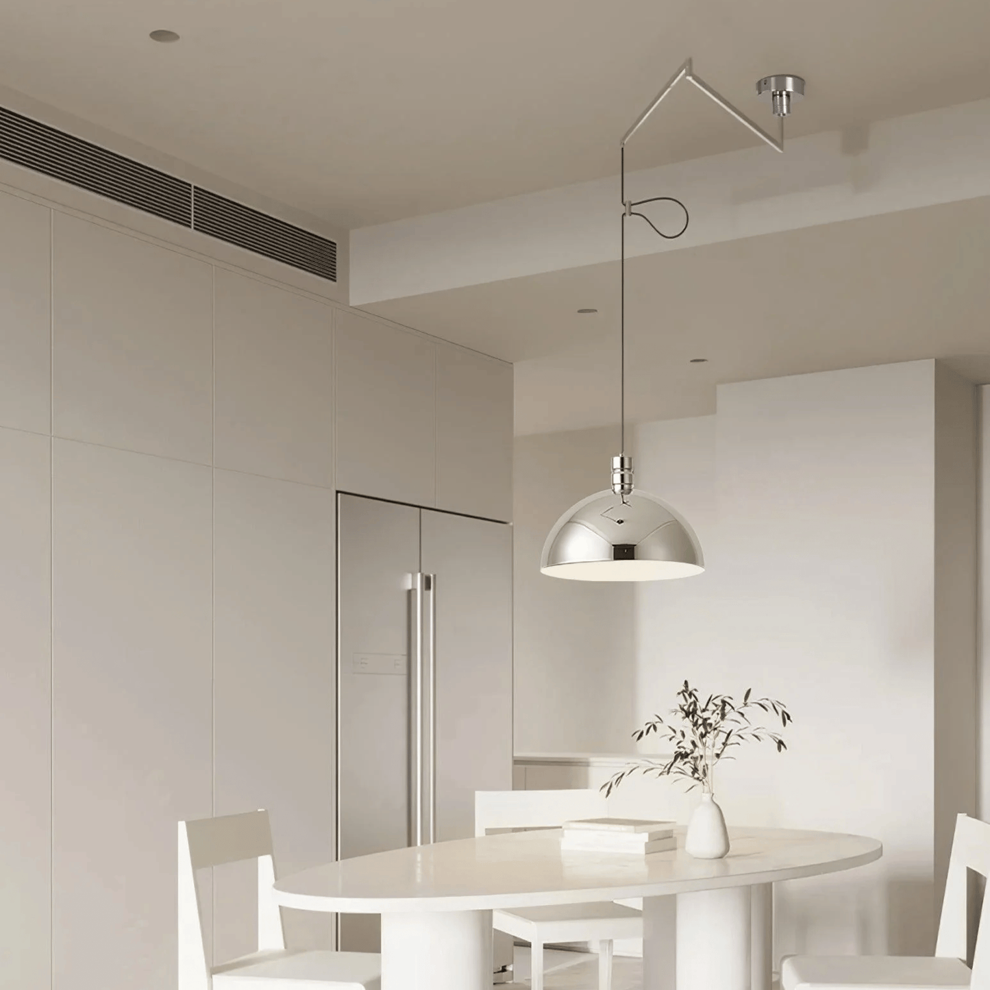 Modern kitchen with a round dining table and chairs, featuring a pendant light.