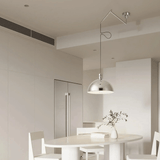 Modern kitchen with a round dining table and chairs, featuring a pendant light.