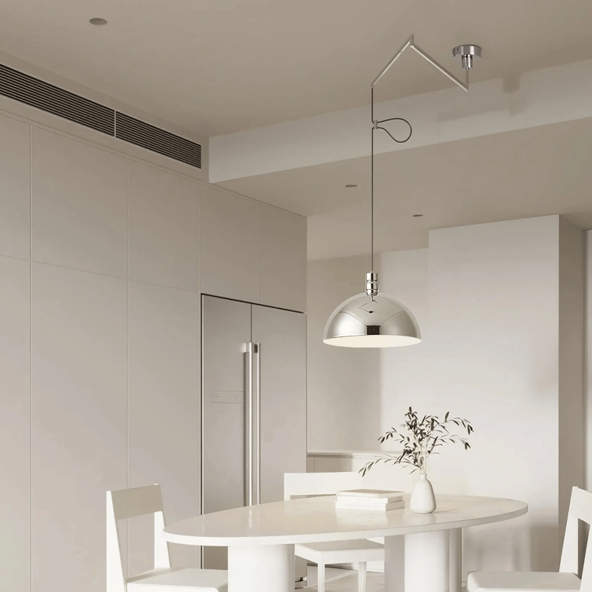 Modern kitchen with a round dining table and chairs, featuring a pendant light.