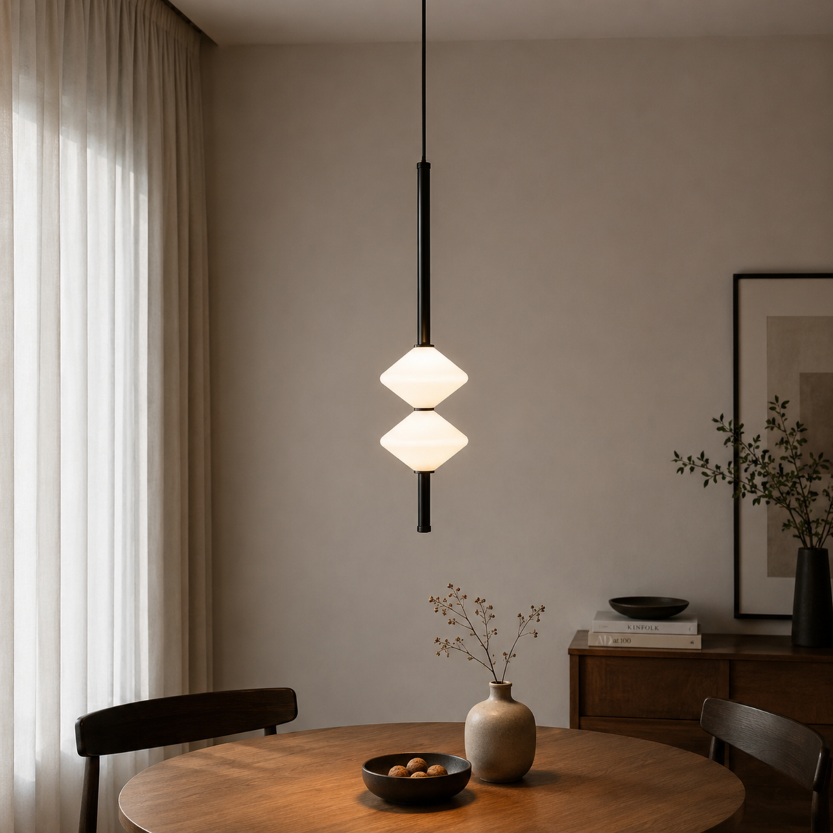 Modern pendant light hanging above a wooden table in a room with neutral decor.