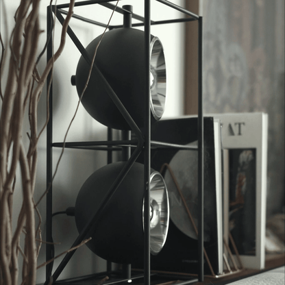 Decorative shelf with black spherical objects and books in a blurred indoor setting