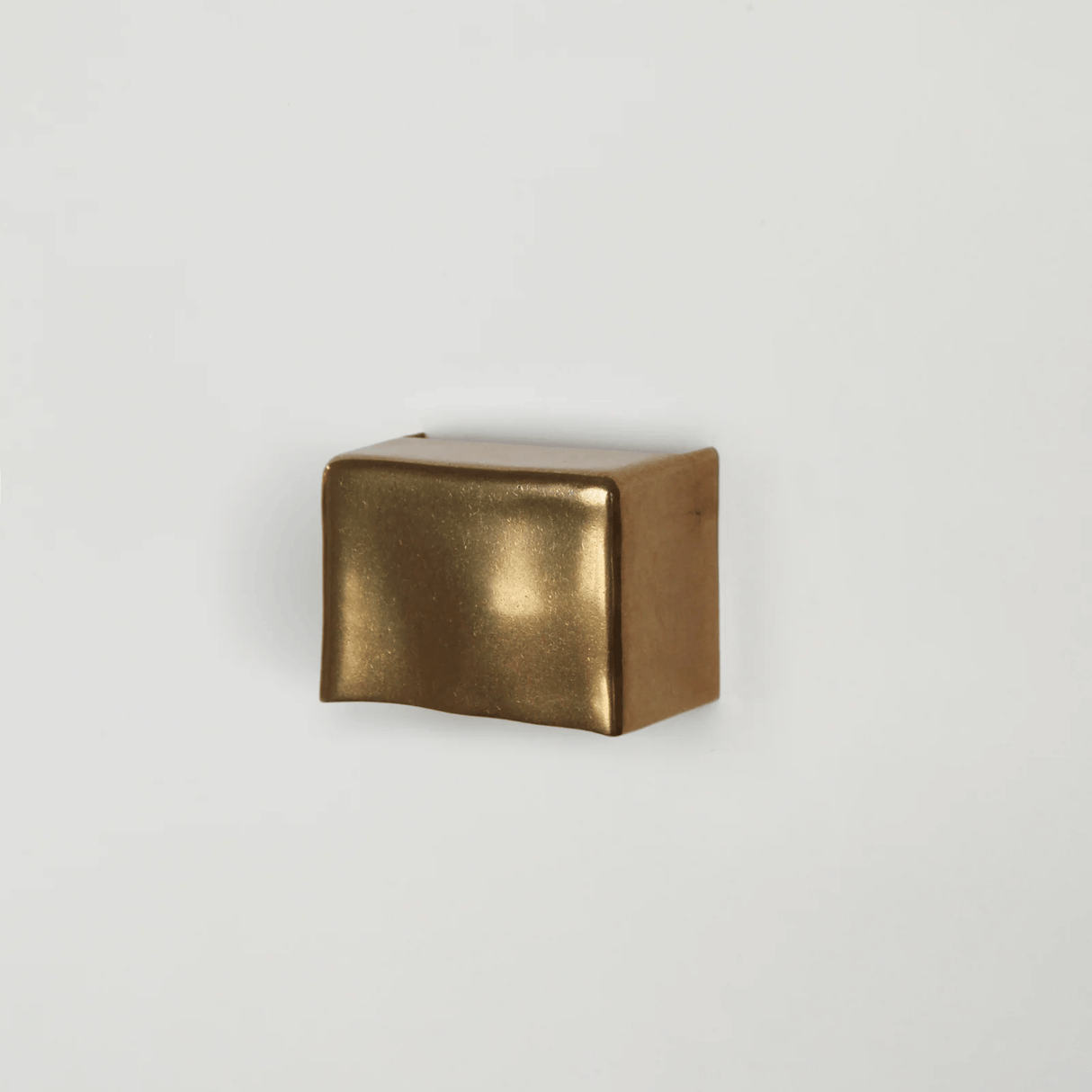 Bronze cube on a light gray background