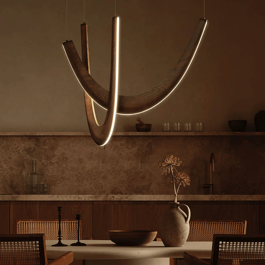 Modern pendant light hanging above a dining table in a dimly lit room.