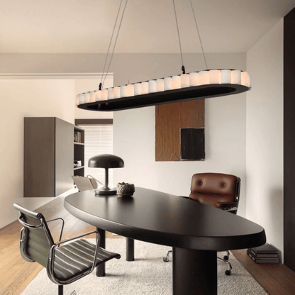 Modern office interior with a black oval desk, chairs, and a stylish pendant light.