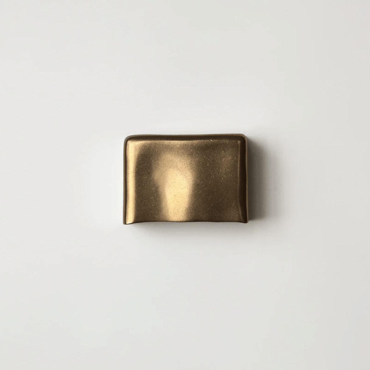 Bronze belt buckle on a light gray background