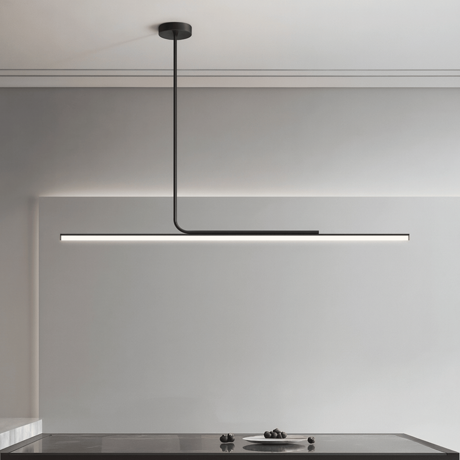 Modern pendant light hanging above a kitchen counter with a neutral background