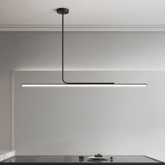 Modern pendant light hanging above a kitchen counter with a neutral background