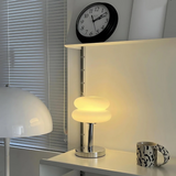 Table with a lamp, clock, and mug in a room setting