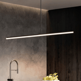 Modern kitchen with dark wood cabinets, concrete wall, and a linear pendant light.