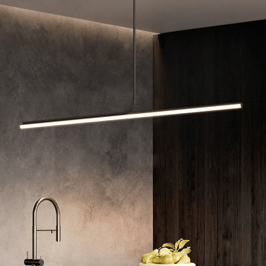 Modern kitchen with dark wood cabinets, concrete wall, and a linear pendant light.