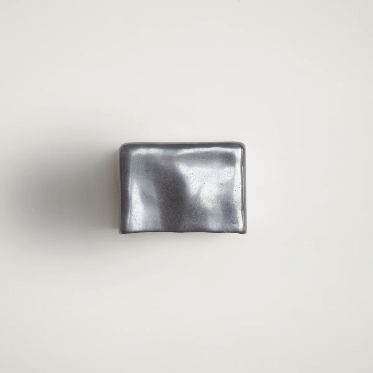 Metallic silver wallet on a light gray background