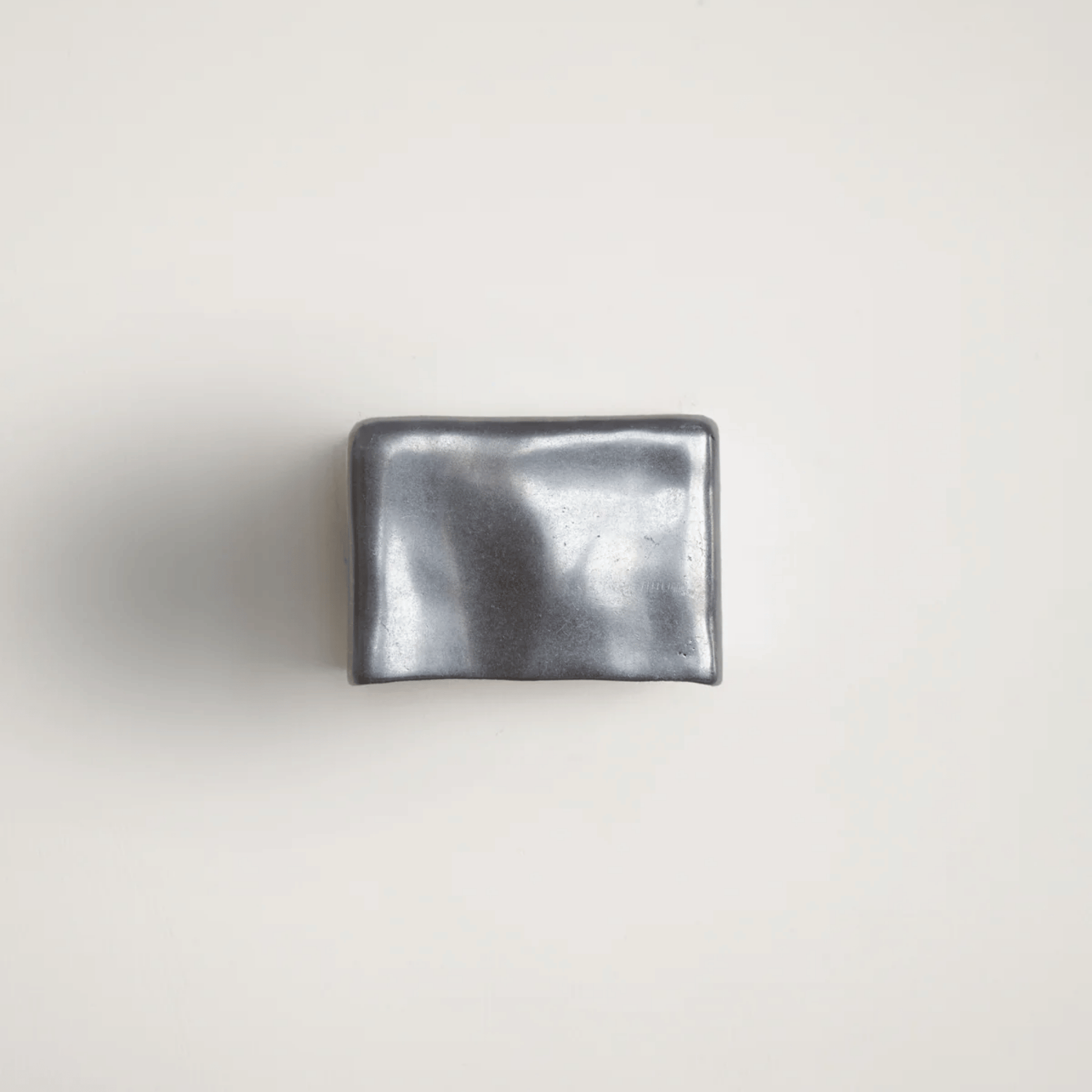Metallic silver wallet on a light gray background