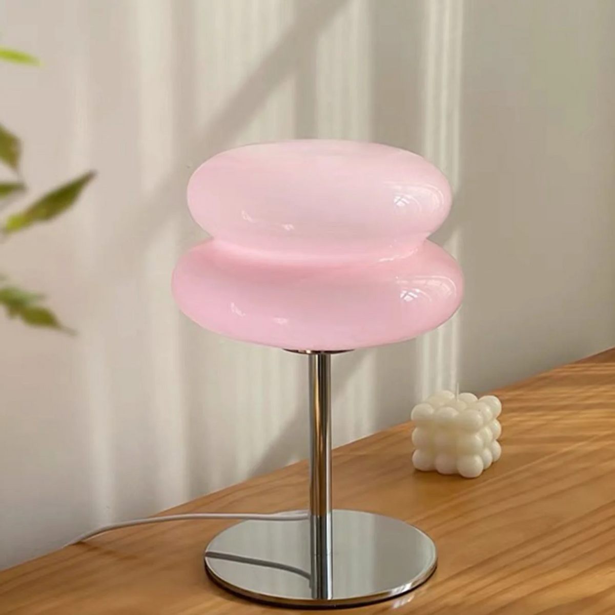 Pink stool with a metallic base on a wooden surface