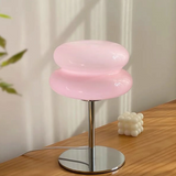 Pink stool with a metallic base on a wooden surface