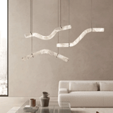 Modern pendant lights hanging above a living room with a neutral color scheme.