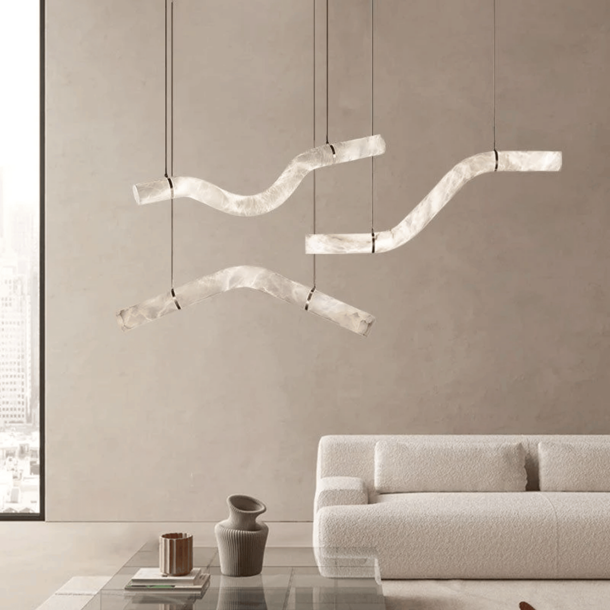 Modern pendant lights hanging above a living room with a neutral color scheme.