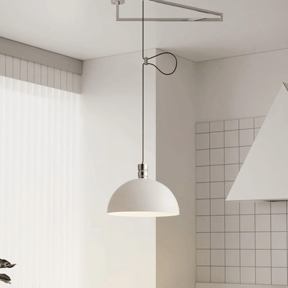 Modern pendant light hanging in a minimalistic room with tiled walls.