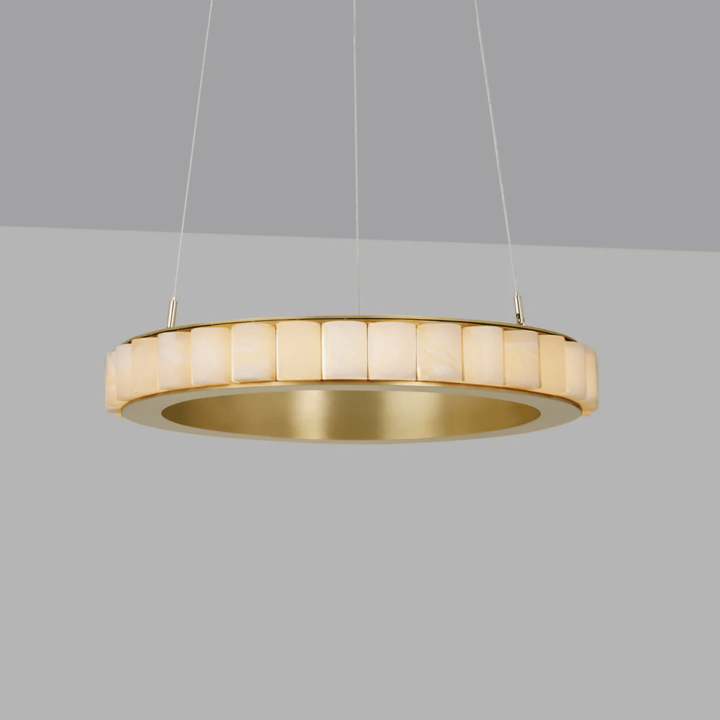 Gold pendant light fixture on a gray background