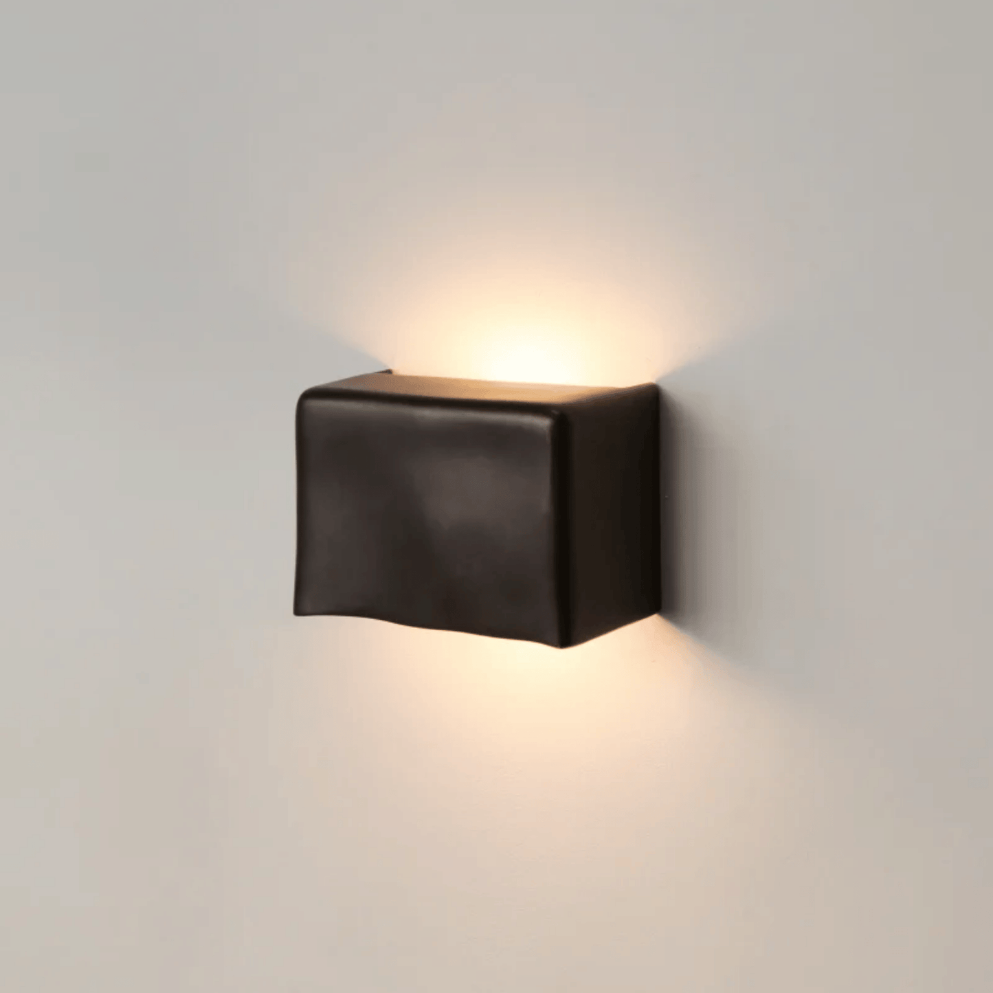 Black square wall light fixture on a gray wall