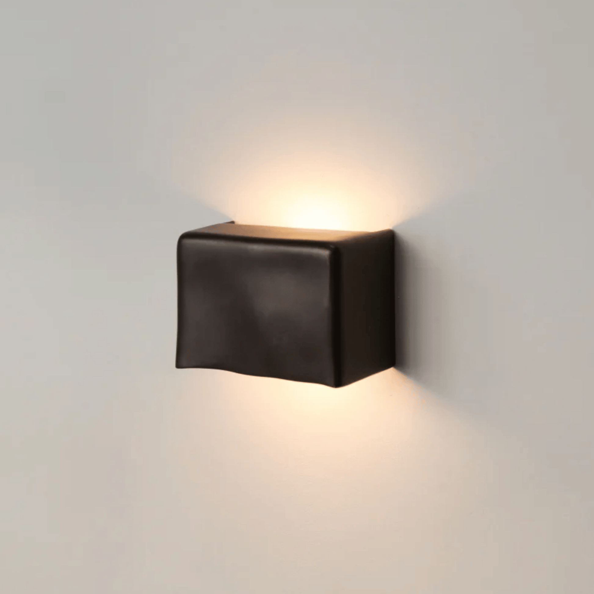Black square wall light fixture on a gray wall
