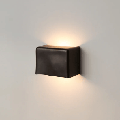 Black square wall light fixture on a gray wall