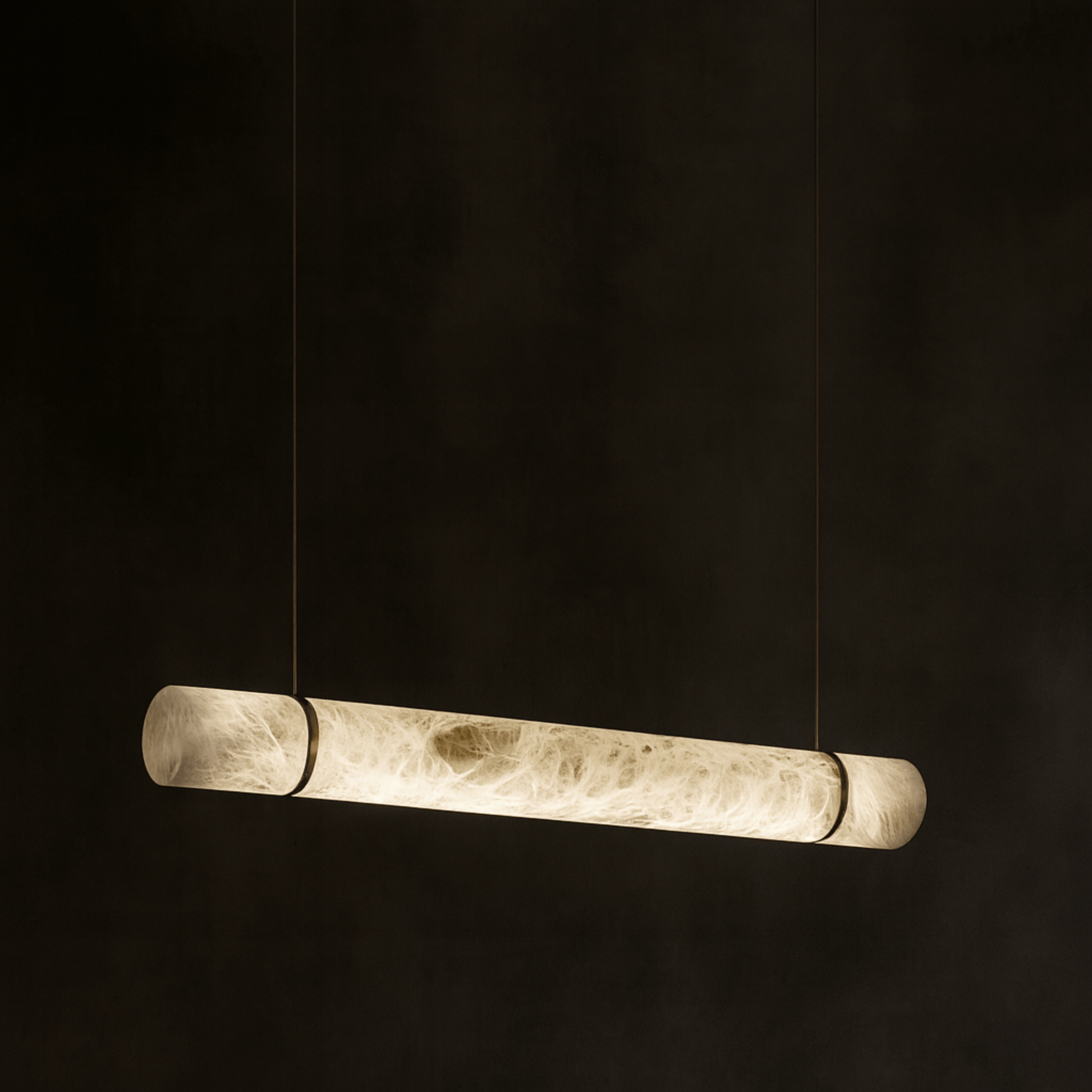 Long cylindrical pendant light on a black background