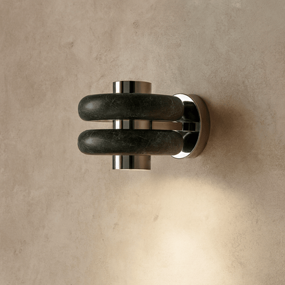 Wall-mounted light fixture with dark marble-like design on a beige wall