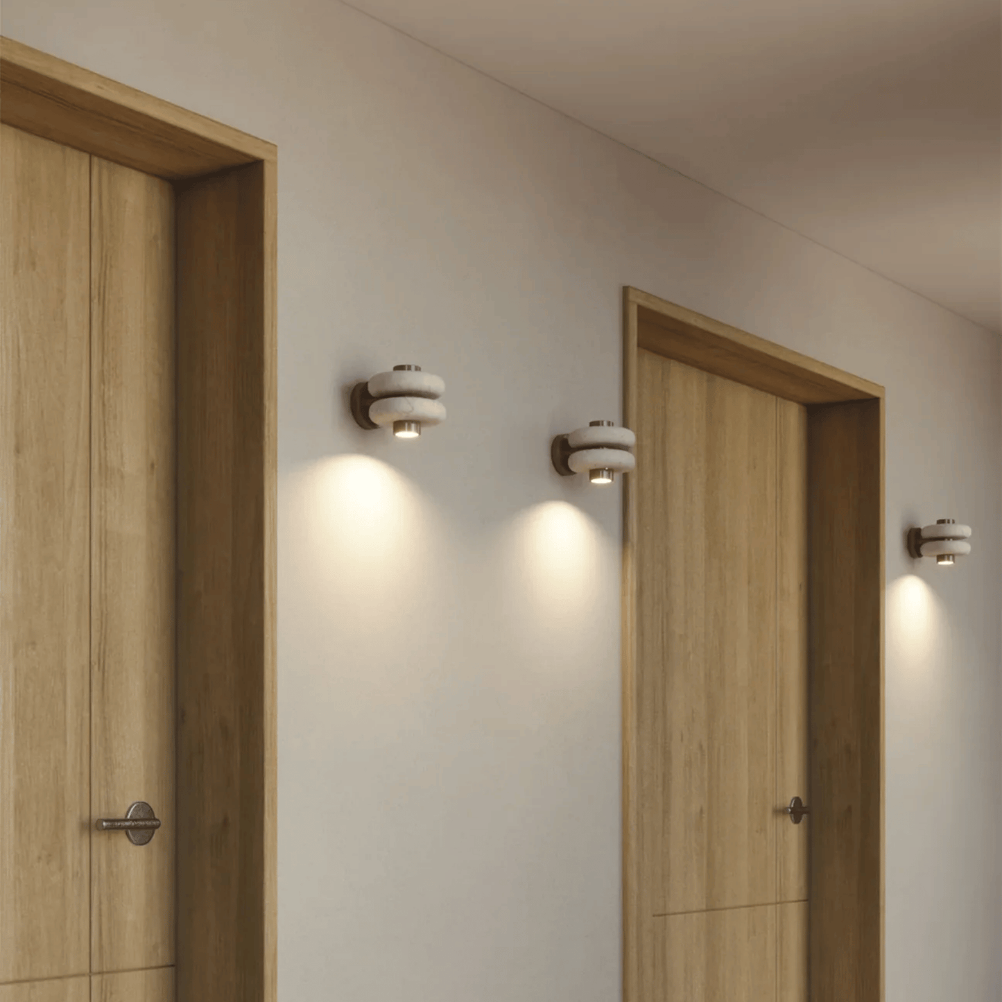 Modern wall lights on a neutral wall with wooden doors.