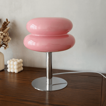 Pink stool with a metallic base on a wooden surface